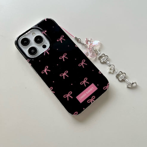 Elegant phone case features a glossy black finish with cute pink bow prints with charm
